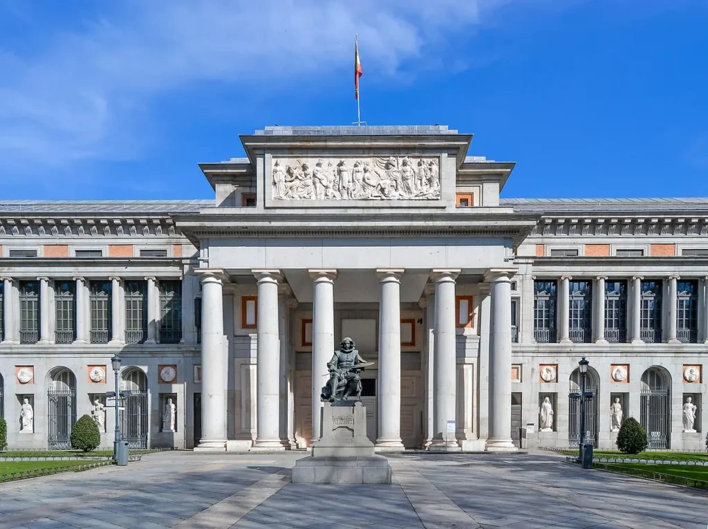 Façade principale du musée du Prado à Madrid, avec la statue de Diego Velázquez au premier plan.