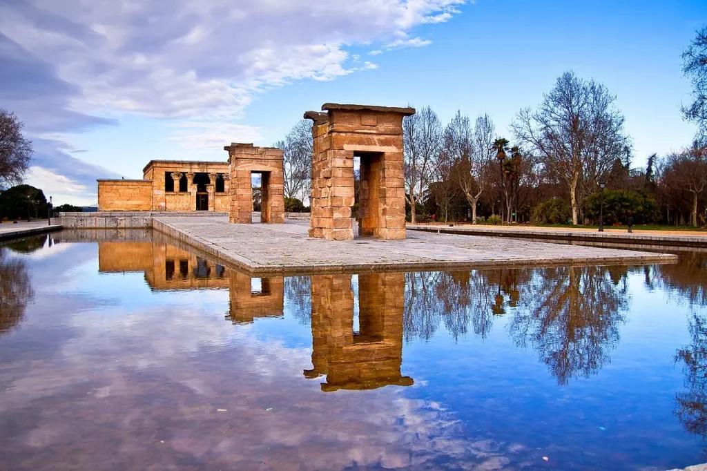Visiter Madrid : les 15 incontournables pour un premier séjour Le Temple de Debod à Madrid se reflétant dans un bassin d'eau, monument égyptien antique situé dans l'ouest de la capitale espagnole.
