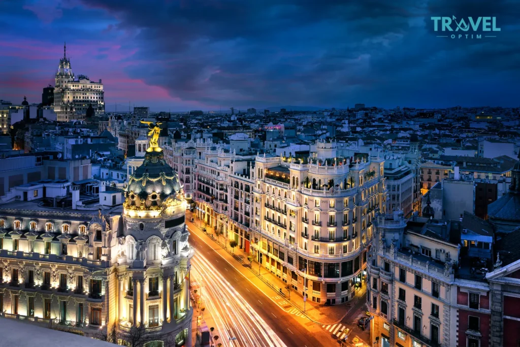 Visiter Madrid : les 15 incontournables pour un premier séjour Panorama de Madrid au coucher du soleil avec la Gran Vía et l'édifice Metrópolis, symbole des incontournables à visiter dans la capitale espagnole.
