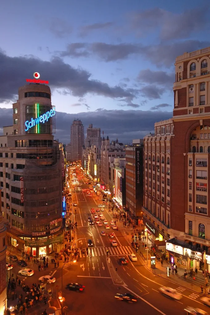 Plaza del Callao à Madrid au crépuscule, avec l'Édifice Carrión et son célèbre panneau Schweppes.